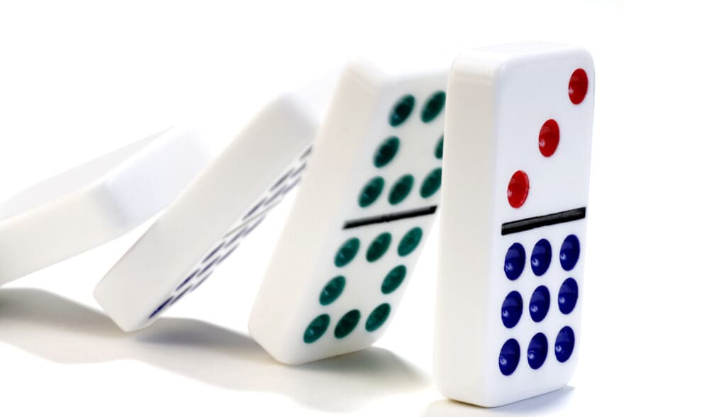 Dominoes falling against each other on a white background.